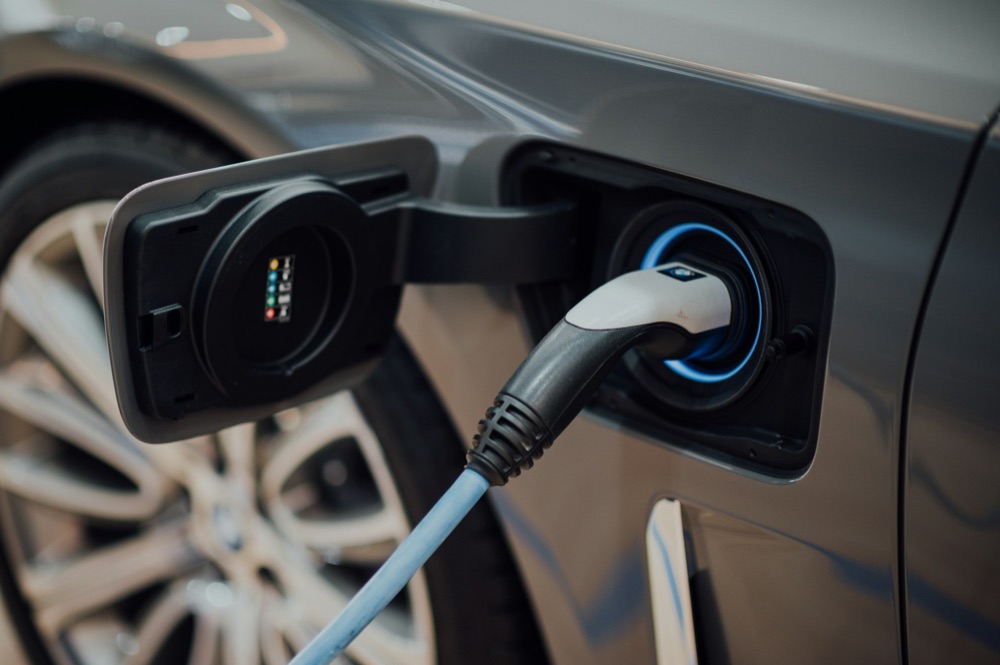 Electrician installing an EV charging station on a garage wall